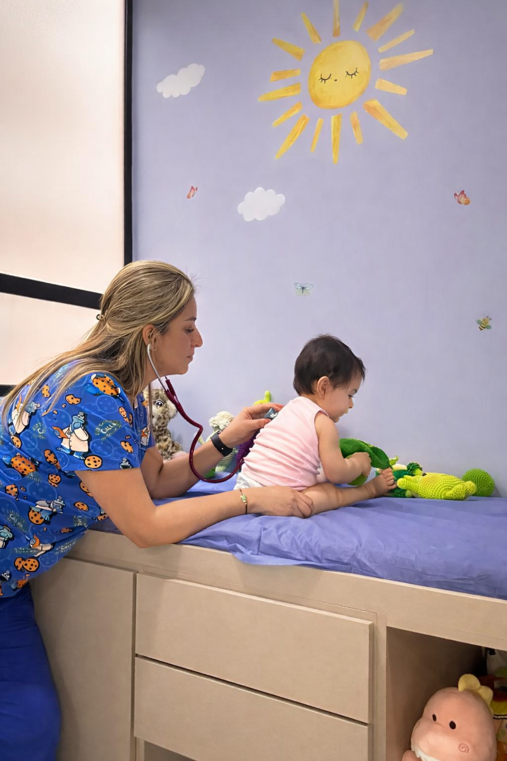 Dra. Adriana atendiendo a un bebé en la camilla